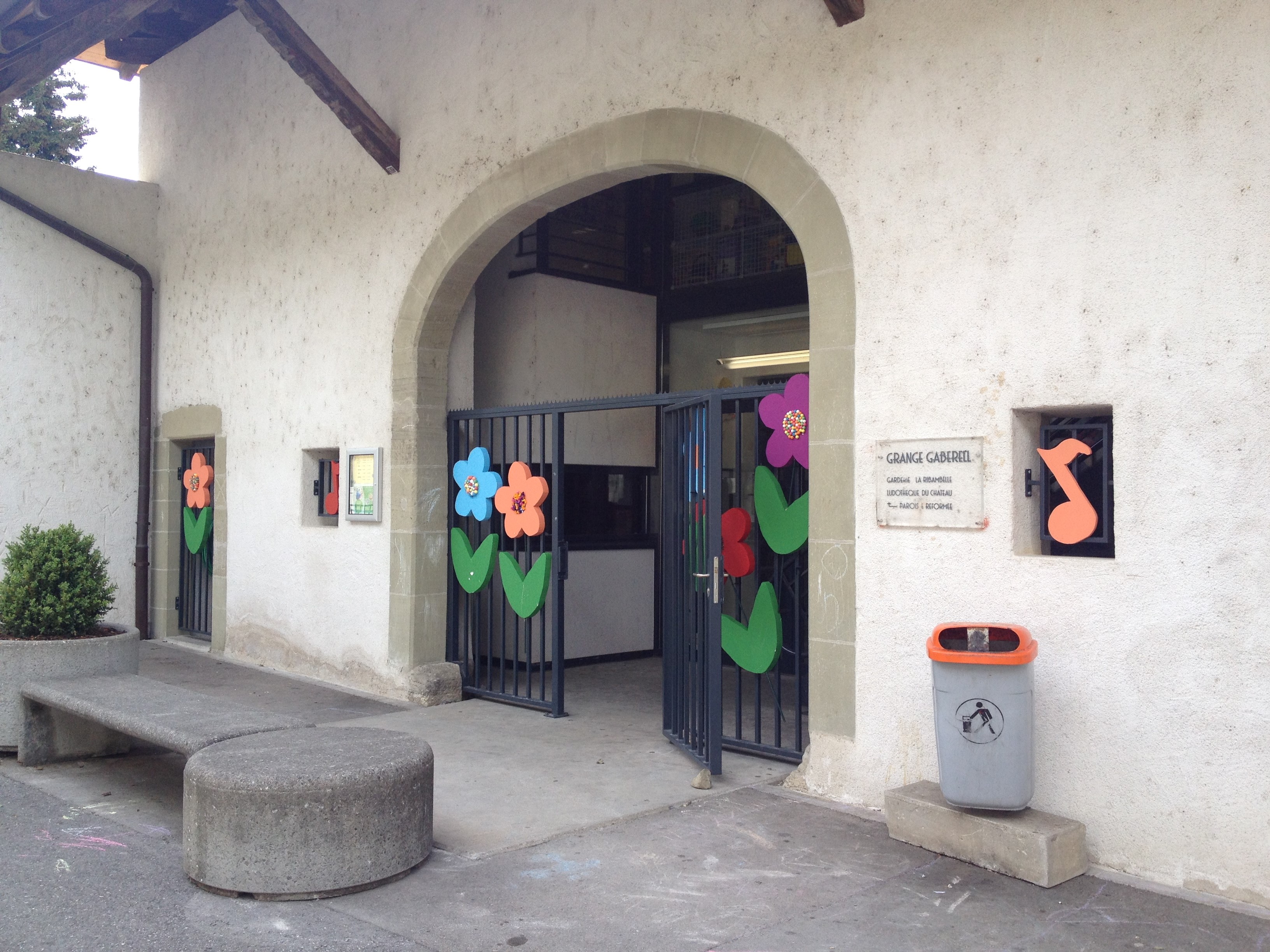 Entrée de la garderie depuis dehors, décorée de fleurs